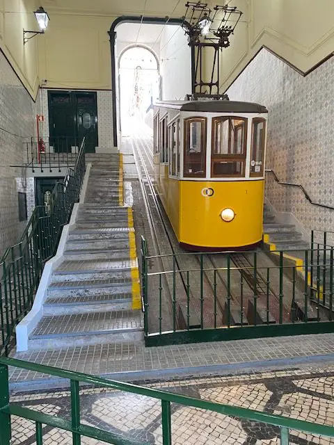 Lisbon's yellow Elevador da Bica funicular at the lower station.  You can ride for free with a Viva Viagem Card or a Lisboa Card