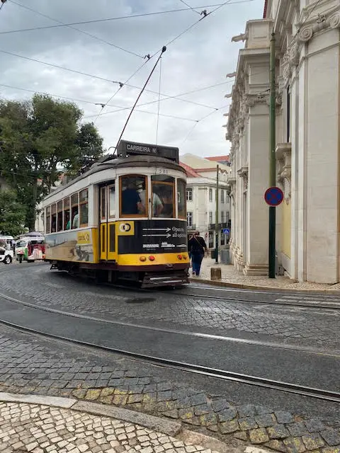 Tram 28 rounds the corner in front of Sé Cathedral, Lisbon, Portugal