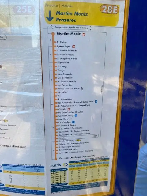 This sign tells where a stop is located on the route of Lisbon's Tram 28.  It also has a time table to help predict when the next tram is coming.