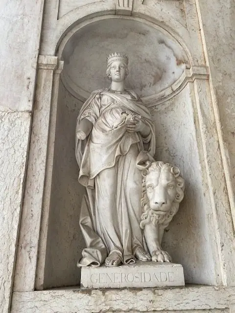 Statue of Virtue of Generosity at the entrance to the Ajuda National Palace in Lisbon, Portugal 