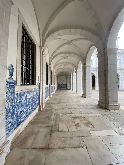 Vaulted white cloisters with blue and white azulejo glazed tile panels at Lisbon's São Vicente de Fora Monastery