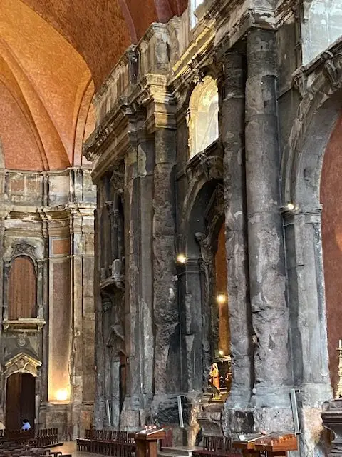 The dark, fire-scarred columns and orange walls of Lisbon's Igreja de São Domingos church