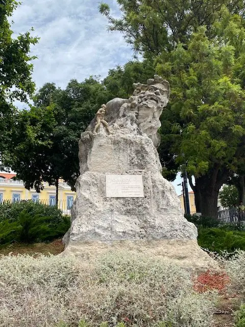 Large white rock statue of Luis de Camões' monster Adamastor (represented by a deformed, angry old man) at the Miradouro de Santa Catarina in Lisbon, Portugal