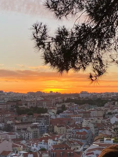Sunset explodes across the horizon at Lisbon's Miradouro da Graça scenic viewpoint