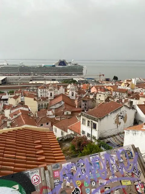 Lisbon cruise ship terminal seen from the Miradouro das Portas do Sol viewpoint with the old houses of Alfama and their terra cotta roofs in the foreground