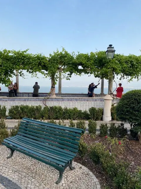 Miradouro de Santa Lluzia has vine-covered pergolas above tiled benches overlooking the Tejo River in Lisbon