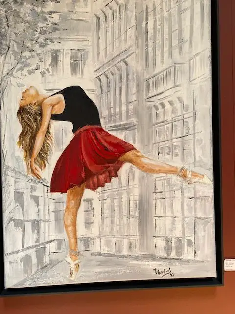 Painting of a young lady frolicking in Lisbon, by artist Maria Godinho on display at Embaixada Shopping Gallery