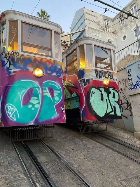 The two graffiti-covered cars of Lisbon's Ascensor do Lavra are parked side-by-side for the night