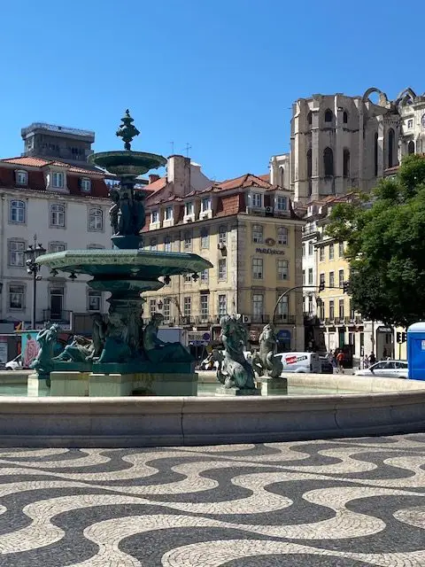 French fountain at the southern end of Rossio Square.  In the top right of the picture you can see the ruins of the Igreja do Carmo Church, damaged in the 1755 earthquake