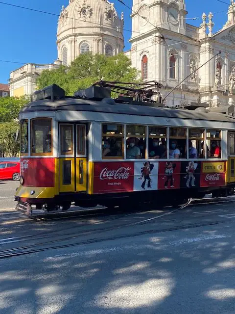 Lisbon's Tram 28E passing in front of the Basilica da Estrela church