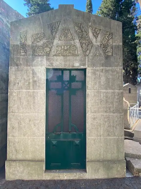 The word "Pax" (Peace), is carved above the dooor of this tomb in Lisbon's Prazeres Cemetery.  The door of the tomb is made out of glass, allowing a view of coffins or photos of the deceeased