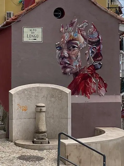 Painting of a woman's face by French-Portugese muralist Hopare at the corner of Rua de O Século and Alto do Longo in Lisbon's Bairro Alto neighborhood