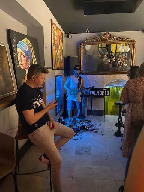 Musician playing and artwork on display at Lisbon's Bar Jobim, Travessa dos Remolares, 25