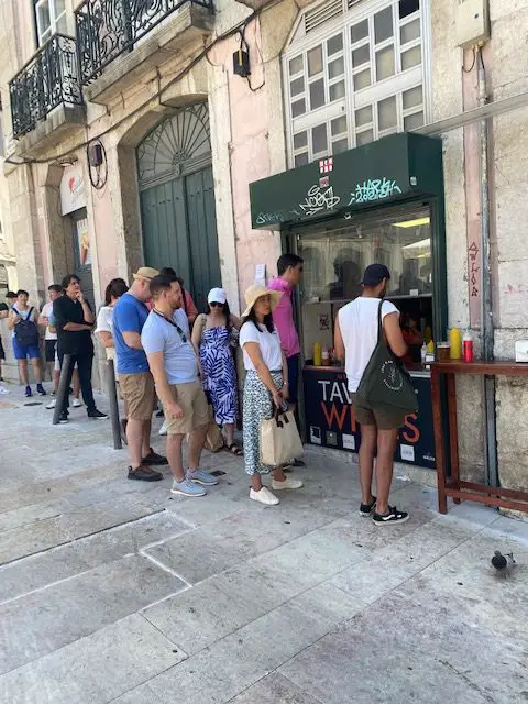 People constantly lineup for a pork sandwich from Lisbon restaurant As Bifanas do Afonso.