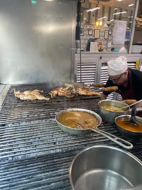 Employee work the grill at A Casa da India - a locals' restaurant in Lisbon, Portugal