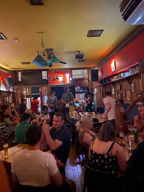 People are having a good time at O'Gillins Irish Pub in Lisbon , Portugal, as a band plays in the background.