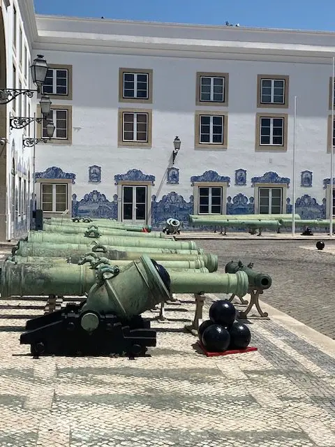 There is a large collection of bronze cannons in the courtyard of the Military Museum of Lisbon.  Beyond the cannons, the white walls are decorated with 26 blue and white azulejo tiles that depict Portuguese battles from the Crusades up to World WAr I.