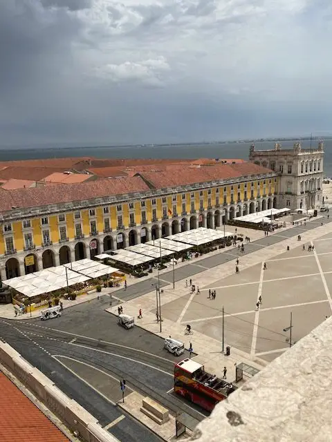 The eastern side of Praça do Comércio seen from the top of the Rua Augusta Arch in Lisbon.  On the left of the photo is the Museum of Beer, and at the right end of the bright yellow building is the Terreiro do Paço Metro Station.  The Terreiro do Paço Ferry Terminal is just out of view.