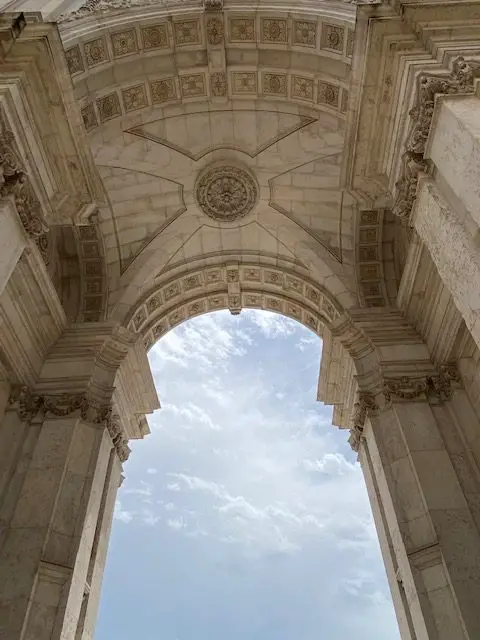 Under Lisbon's Rua da Augusta Arch, looking up at the arch